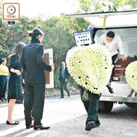 寫上遺孀吳婉芳及三名子女名字的心形花牌伴隨棺木送入寺內。