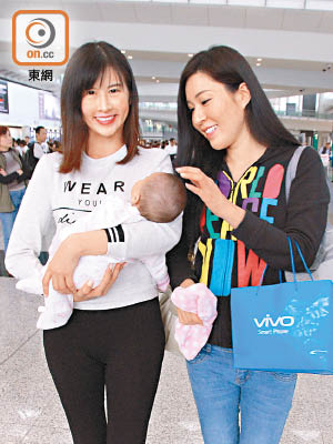 趙哲妤抱着愛女離開機場，在旁的筱靖不停逗玩B女。