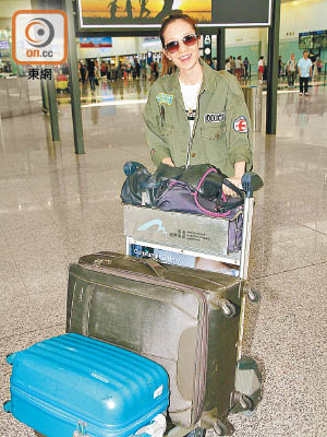 王君馨推着行李車離開機場。