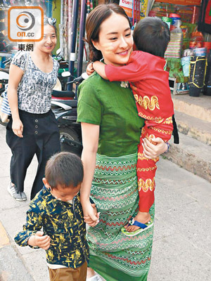 陳瀅換上緬甸服飾，拖一個、抱一個行街街。