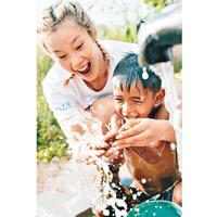 歐鎧淳與當地兒童分享潔淨的食水。