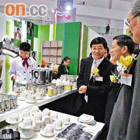 貿發局喺重慶舉行嘅「香港時尚購物展」加設香港茶餐廳專區，總裁林天福（右三）請當地官員品嘗港式奶茶。