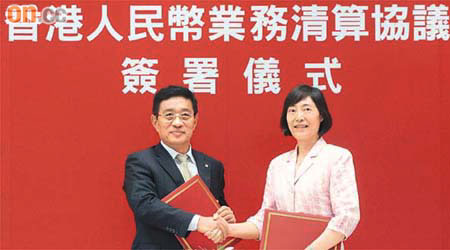 人行副行長胡曉煉（右）與中銀香港總裁和廣北簽署新修訂的人民幣業務《清算協議》。（蘇文傑攝）