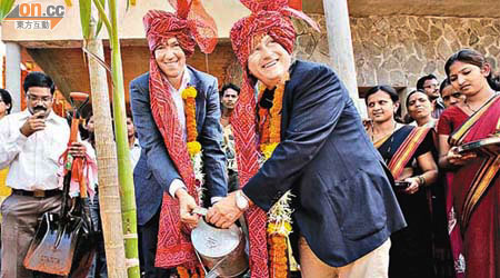 思捷行政總裁范德施（左）及主席高漢思（右）穿上民族服裝，為新嘅兒童村揭幕。