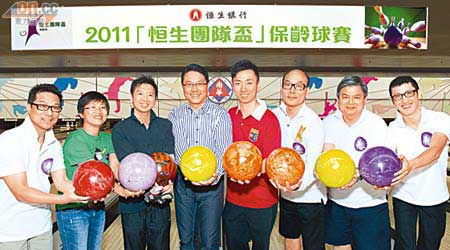 恒生陸庭龍（左四）、香港保齡球隊代表胡兆康（右四）及比賽嘅冠軍隊員合照留念。