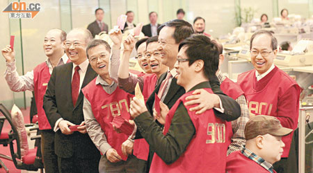 港交所行政總裁李小加（前排右二）向出市員大派利是，前排左二為主席周松崗。（蔡綺琳攝）