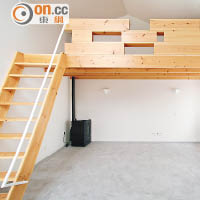 建築師於大廳建造的一條木樓梯，同時亦建構成屋內的家具布置之一，藉此擴闊空間。
