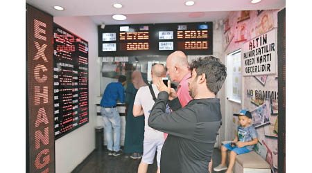 土耳其貨幣大貶值，當地市民紛紛到兌換店換美元鈔。（美聯社圖片）