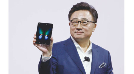 南韓三星電子流動通訊業務總裁高東真早前在發布會上，展示新推出的摺屏手機Galaxy Fold。（美聯社圖片）