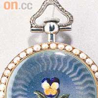 三色堇腕錶，約1900年作品，圓形的錶殼周圍鑲有珍珠，中央為帶葉的三色堇，栽種在淡紫色琺瑯土地上。