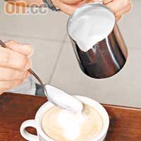 把打起的奶泡倒入咖啡中，可先以湯匙隔着壺嘴，以控制倒奶的速度。
