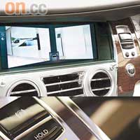 中控台正中央的木製飾面背面，是隱藏式顯示屏，按鍵便會顯示車身左右和泊車鏡頭的畫面。