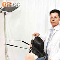註冊脊醫及物理治療師何應輝（右）示範為陳小姐進行「拉頸」治療。