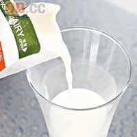 把高鈣低脂牛奶倒於杯中。