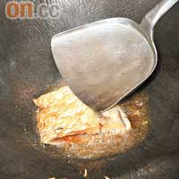 薑切絲備用；燒紅鑊倒油，放入鹹魚煎至皮脆並呈金黃色。
