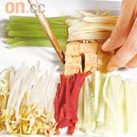 步驟3　將油筍乾條、青瓜絲、芽菜、紅椒絲、薑絲、油豆腐、豆豉小魚乾、葱花、西芹條及粟米整齊放在碟上。