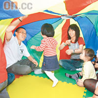 手腳協調訓練：小朋友與家長一同玩彩虹傘，並由導師提出指令，如1號風球、8號風球等，讓小朋友跟住指令搖動彩虹傘，訓練聽覺與手腳的配合。