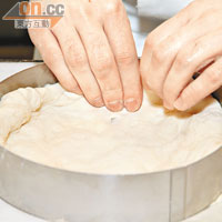 在蛋糕模上噴些欖油，把麵糰鋪在圈內，並於中間壓實形成窩巢狀。把水牛芝士片鋪滿底層，並把其壓實於麵糰中。