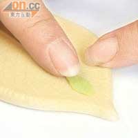 取出綠色手工麵粉，用葉模壓出葉形。