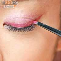 Step 2 用黑色眼線筆貼近睫毛根部，畫條內眼線。然後可把眼影掃弄濕，沾取粉紅色眼影畫條向上翹的粗身眼線。
