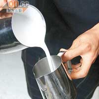將奶泡均勻地倒進另一拉花杯裏，使奶和奶泡比例平均。
