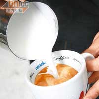 把奶泡倒進咖啡杯裏拉成理想的圖案。
