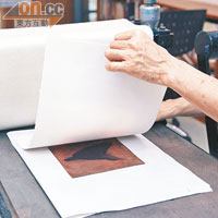 Step 5將銅版放於壓印機上，鋪上浸過的紙張，再蓋上一層的軟毛墊，以增加紙張與銅版的貼合度。