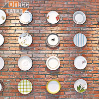 紅磚牆上掛滿各式陶瓷餐碟，如一件件的藝術品。