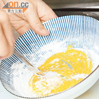 將蛋黃拌勻後，一定要逐少逐少加入生粉，令生粉完全與蛋汁結合，不會起粒，炸漿才會脆薄。