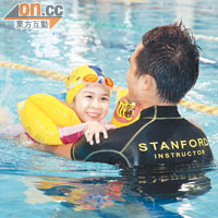 小朋友扶着導師熟習水中暢泳的感覺。