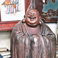 這座用樹根雕成的笑佛像，據知乃名家裘中平的作品，叫價$38,000。