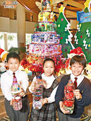 （左起）何嘉耀、劉嘉儀及李寶賢同學與水樽聖誕樹合照。