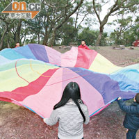 以彩虹傘、穿呼拉圈等集體遊戲作熱身，可讓小朋友感受到愉快氣氛，玩得更投入。
