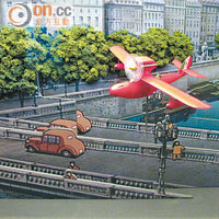 紅豬俠專機，正飛過由層層紙板製成的立體街道。