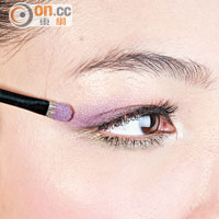 2 用紫色眼影由眼窩中央向外掃，稍稍掃出眼角位，造出漸層效果。