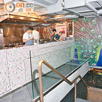 開放式廚房設於地面樓層，搶眼之處是用上麻雀牌和開屏孔雀裝飾，處處流露出香港本土風味。