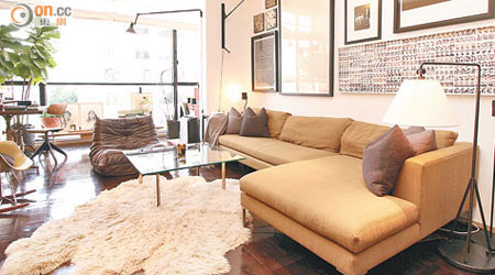 客廳焦點是一張泥黃色L形梳化，襯上一幅白色軟毛地氈，有型又舒適。