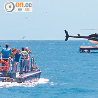 乘客要乘駁艇，才能登上泊在海中的直升機。