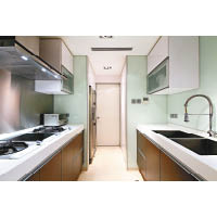 廚房分為兩部分，煮食間以粉綠色配搭深啡色的落地廚櫃。