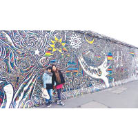 兩個女生在柏林的East Side Gallery前合照，感受當地的文化氣息。