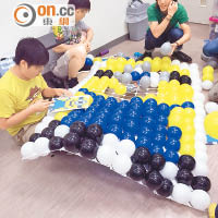 一眾學員埋頭苦幹地創作大型氣球造型。