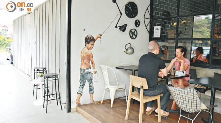 Zachas於Cafe門旁畫上了一位小男生的壁畫，拉繩斟茶動作相當生動有趣。