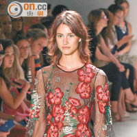Jenny Packham <br>透視連身裙飾有紅色的刺繡花卉，猶如在皮膚上一樣，幾可亂真。