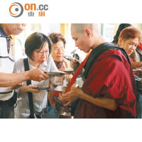 來自不同地方的佛教徒爭着供奉不同物品給予和尚們。