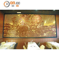 餐廳牆身飾有一幅金光閃閃的馬賽克圖，隱約可見一隻黑毛豬及其身後的橡果樹，黑金色調營造出型格摩登格調。