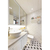 浴室以白色為主調，運用不同物料凸顯層次，地磚則砌成黑白花紋，一掃沉悶感。