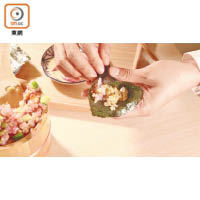 把適量海鮮飯放在紫菜上，包成手卷食用。