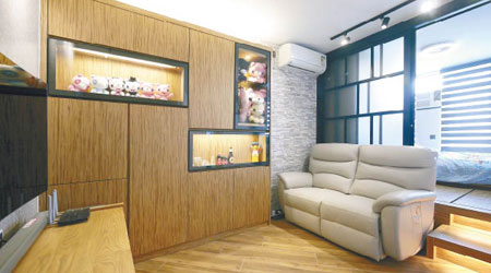 為了給單位添加暖意，設計師特別選用了木紋地板，再襯以木紋高身飾物櫃。