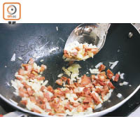 2. 炒香洋葱粒後加入肉腸粒，炒至肉腸滲出鹹香油脂。