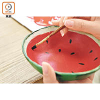 8.先預留碗邊位置，於碗內塗上紅色塑膠彩，再在碗邊塗上白色塑膠彩，風乾後，再利用黑色塑膠彩於碗內畫上適量核子。待其風乾後，西瓜造型的陶瓷碗即告完成。
